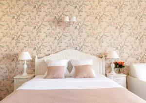 a bedroom with a bed with pink floral wallpaper at Cannes Imperial Croisette Palais Miramar in Cannes