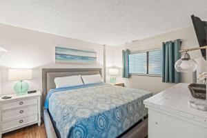 a bedroom with a bed and a desk and a window at Oceanfront Condo, Steps to the Beach in Myrtle Beach +30 photos