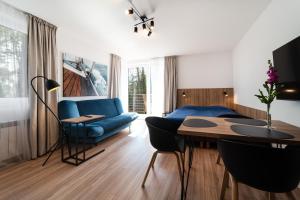 a living room with a blue couch and a table at Willa Juranda in Jurata