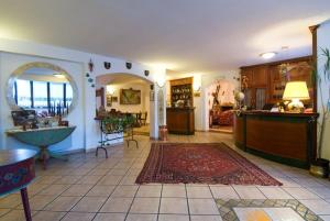 a living room with a counter and a room with a rug at LH Albergo Il Paradiso in Pescasseroli