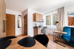 a small apartment with a blue couch and a kitchen at Willa Juranda in Jurata