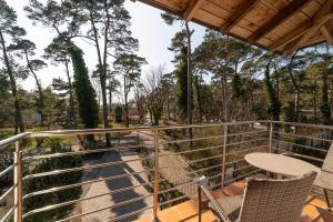 a balcony with chairs and a table and trees at Willa Juranda in Jurata