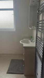 a white bathroom with a sink and a window at King Room sheared house in Bristol