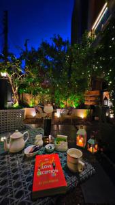a table with a book and cups and dishes on it at Victorian Elegance Luxury Stays in Amritsar