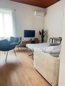 a bedroom with a bed and a chair and a television at Vintage House in Asciano