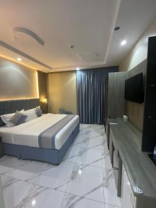 a hotel room with a bed and a flat screen tv at فندق اجنحه البيداء فرع2 AlBaydaa Suites Hotel Branch in Medina