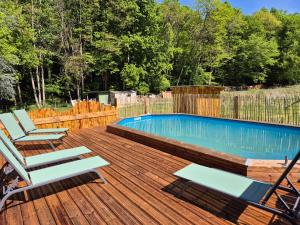 a deck with chairs and a swimming pool at La Cabane du Porteau in Saint-Georges-sur-Cher