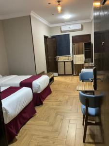 a hotel room with a bed and a desk and a table at اجنحه البيداء فرع الدفاع in Medina