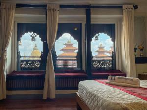 a bedroom with two beds and a window with a view at Lalit Heritage Home in Pātan