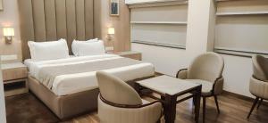 a hotel room with a bed and two chairs at Hotel Pallavi Grand in Panchkula