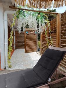 a patio with a pergola with a bench and flowers at Domaine kaliope in Le Robert
