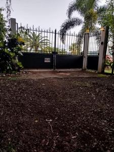 a black gate with a palm tree behind it at Domaine kaliope in Le Robert +1 photo