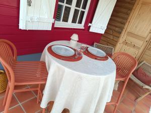 a table with a white table cloth and two chairs at Domaine kaliope in Le Robert