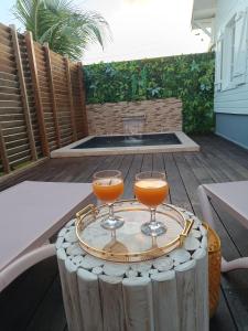 two glasses of orange juice sitting on a table at Domaine kaliope in Le Robert