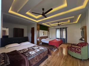 a bedroom with two beds and a ceiling fan at North Queen Resort in Mal bazar