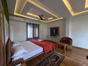 a bedroom with a bed and a ceiling fan at North Queen Resort in Mal bazar +7 photos