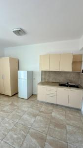 an empty kitchen with white cabinets and a tile floor at Dhermi Light Rooms in Dhërmi +22 photos