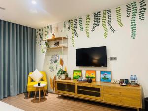 a living room with a television and a yellow chair at Sweet Home in Gò Ba Quần