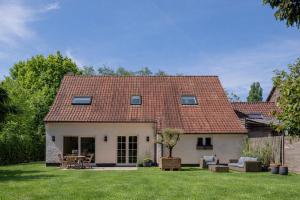a white house with a red roof at Boutique Suite with Garden near Ghent in Sint-Martens-Latem