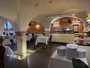 a restaurant with white tables and chairs and a kitchen at Celestin Residence in Gdańsk