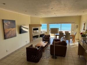 a living room with a couch and a table and a dining room at 25 Sunset View in Langstrand