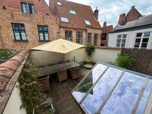 an outdoor patio with an umbrella and a bench at Clemanbruges in Bruges