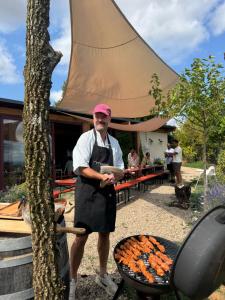 a man in an apron standing next to a grill at La Colline Digoin in Digoin