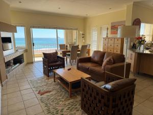 a living room with a couch and a table at 25 Sunset View in Langstrand