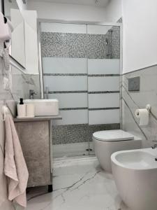 a white bathroom with a toilet and a sink at Mister House in Fiumicino +37 photos