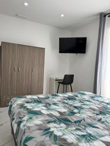 a bedroom with a bed and a tv on the wall at Mister House in Fiumicino