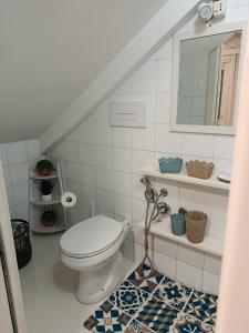 a white bathroom with a toilet and a mirror at Casa vacanze So Suite 24 in Reggio di Calabria +16 photos