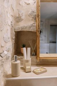 a shelf with a mirror and some items on it at Anemolithos Mani's House in Areopoli +35 photos