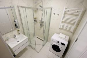 a bathroom with a shower and a washing machine at Mira Seaview Studio Apartment in Batumi in Batumi +11 photos