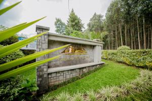 a stone wall with a fire pit in a garden at Virunga Inn Resort & Spa in Kinigi