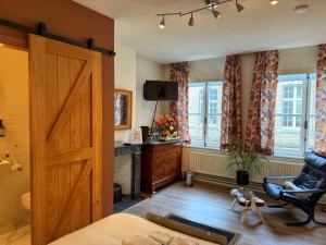a bedroom with a large wooden door and a chair at Clemanbruges in Bruges