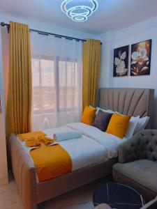ein Schlafzimmer mit einem Bett, einer Couch und einem Fenster in der Unterkunft yNest Studio in Syokimau