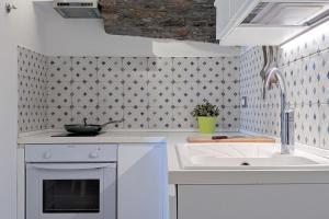 a white kitchen with a sink and a sink at Casa Di Mezzo by Arbaspàa in Manarola +201 photos