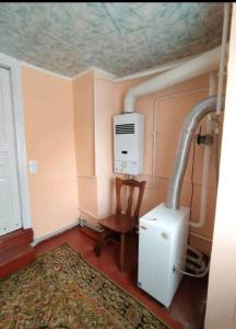a small room with a heater and a chair and a table at Halvy 60 Apartments in Cherkasy