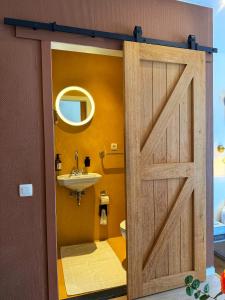 a bathroom with a wooden door and a sink at Clemanbruges in Bruges +47 photos