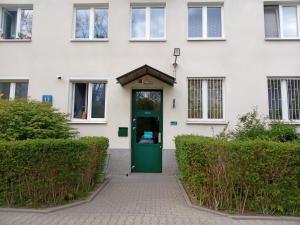 an entrance to a white building with a green door at E-Brechta in Warsaw
