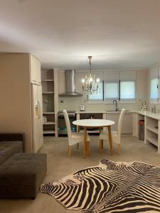 a kitchen and dining room with a table and chairs at Wave Rider Villa in Kouvéla