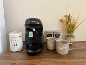 a coffee maker and cups on a table at StayU Apartment in Ústí nad Labem +5 photos