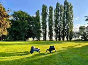 two chairs sitting in the grass in a field at La Maison Maya Normandie in Saint-Éloi-de-Fourques
