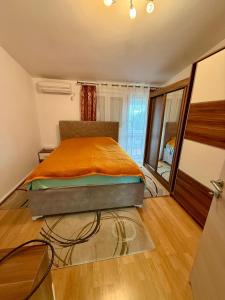 a bedroom with a bed with an orange blanket at King Apartment in Sutomore
