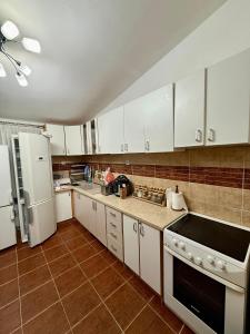 a kitchen with white cabinets and white appliances at King Apartment in Sutomore