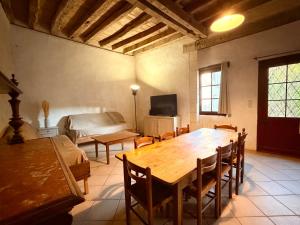 a living room with a wooden table and a bed at Aux Ecuries du Signe in Amboise
