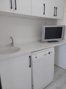 a kitchen with a sink and a tv on a counter at Alaçatı evi in Alaçatı +1 photo