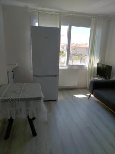 a living room with a refrigerator and a table at Alaçatı evi in Alaçatı