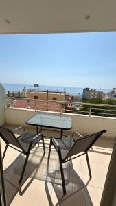 a balcony with a table and chairs on a roof at Dhermi Light Rooms in Dhërmi