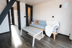 a living room with a blue couch and a table at WAKE INN by Pidu-LA in Abula